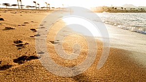 Beautiful view on the sun setting down over the sea. Beautiful sandy sea beach and waves rolling over the shore