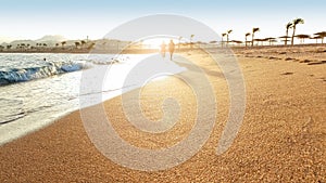 Beautiful view on the sun setting down over the sea. Beautiful sandy sea beach and waves rolling over the shore