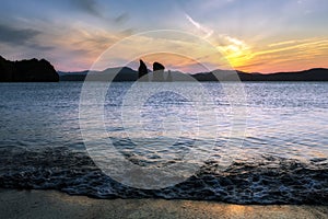 Beautiful view of sunset over rocks in sea