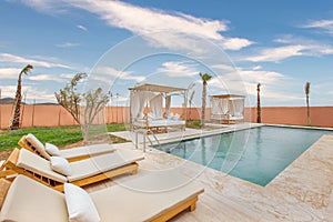 Beautiful view of a swimming pool with resting beds and chaise-lounges