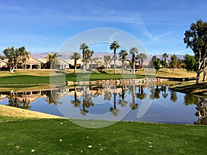 A beautiful view from the tee box of a difficult par 3 that requires a shot over the water onto an island green.