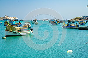 Beautiful view on the traditional eyed colorful boats Luzzu in the Harbor of Mediterranean fishing village Marsaxlokk, Malta