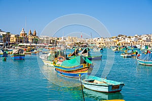 Beautiful view on the traditional eyed colorful boats Luzzu in the Harbor of Mediterranean fishing village Marsaxlokk, Malta