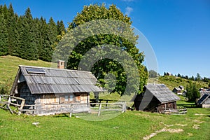 Beautiful view of traditional wooden cabins in the idyllic Slovenian mountains.