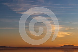 Beautiful view of Trasimeno lake Umbria, Italy at sunset, with orange and blue tones in the sky