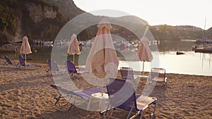 Beautiful view of tropical beach with chairs, umbrellas and moored yachts