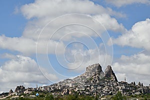 Beautiful view of the Uchisar Castle under the blue sky with clouds in Tekelli, Turkey