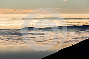 Beautiful view of Umbria valley Italy covered by a sea of fog at sunset, with beautiful warm colors and trees