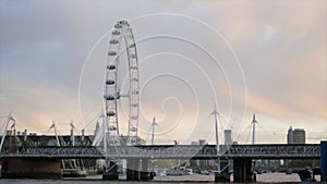 Beautiful view of waterfront with Ferris wheel on background of sunset sky. Action. Ferris wheel is located on