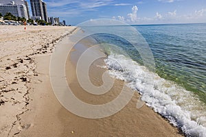 Beautiful view of waves of Atlantic Ocean rolling onto sandy beach of Miami Beach.