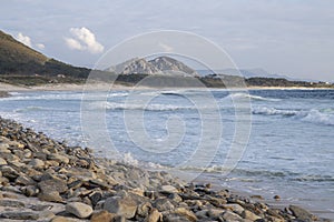 Beautiful view of the wavy ocean hitting the rocky Larino beach in Galicia photo