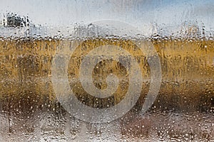 A beautiful view of the winter city and yellow building and blue sky through the frozen window glass with different size