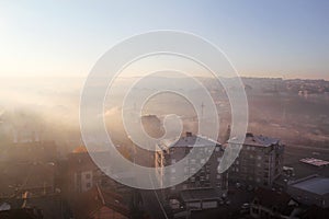 Beautiful view of winter morning fog filling on landscape of houses and buildings in Belgrade. Scenery during sunrise.