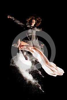 Beautiful view of woman elegantly jump high in the air at dark time