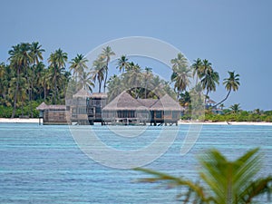 Beautiful view of wooden overwater villas near a white sand tropical beach.