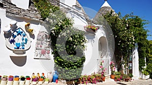 Beautiful village of Alberobello with trulli houses among green plants and flowers, main touristic district, Apulia region, Southe