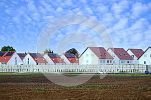 beautiful village landscape, row cottages, houses behind fence, arable land, fields, blue skies, agricultural concept, growing