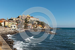 A beautiful village in Liguria on a promontory overlooking the sea. There are rocks and fishing boats