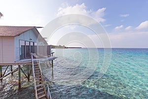 Beautiful villas over water on tropical island resort in Maldives with turquoise sea