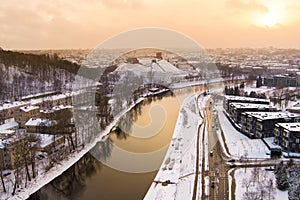 Beautiful Vilnius city panorama in winter with snow covered houses, churches and streets. Aerial sunset view. Winter city scenery