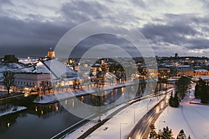 Beautiful Vilnius city panorama in winter with snow covered houses, churches and streets. Aerial sunset view. Winter city scenery