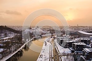 Beautiful Vilnius city panorama in winter with snow covered houses, churches and streets. Aerial sunset view. Winter city scenery