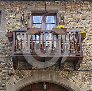 Beautiful vintage balcony with colorful flowers and wooden doors.