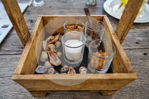 Beautiful vintage wooden box basket holding sugar glasses and spoon for coffee and tea with sea shell decoration on wooden table