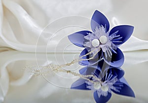 Beautiful violet origami flower on white background