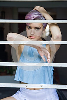 A beautiful violet short-haired woman behind a fence