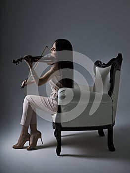 Beautiful Violinist Woman playing electric violin on white backg