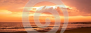 Beautiful vivid orange dusk sky over beach and ocean in Povoa de Varzim, Portugal