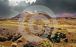 Beautiful volcanic landscape, dramatic sky storm clouds, volcano crater, lava sand ash field - Timanfaya NP, Lanzarote