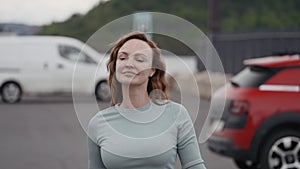 Beautiful walking woman. Action.A young model with wavy red wavy hair walking with a flying gait in the park.