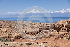 The beautiful wasteland of Skazka Canyon with Lake Issyk-Kul in the background in Kyrgyzstan