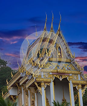 Beautiful Wat Buddhist temples in Phuket Thailand. Decorated in beautiful ornate colours of red and Gold and Blue. Lovely sunset