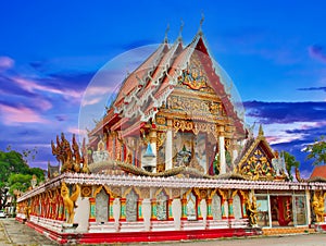 Beautiful Wat Buddhist temples in Phuket Thailand. Decorated in beautiful ornate colours of red and Gold and Blue. Lovely sunset