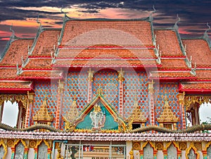 Beautiful Wat Buddhist temples in Phuket Thailand. Decorated in beautiful ornate colours of red and Gold and Blue. Lovely sunset