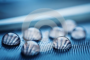 Beautiful water drops on the feather. Macro. Beautiful soft light blue and violet background. Selective focus