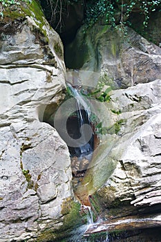 Beautiful water stream flows from mountain cave