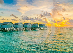 Beautiful water villas in tropical Maldives island at the sunset