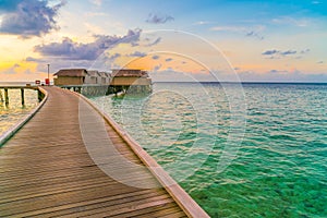 Beautiful water villas in tropical Maldives island at the sunset