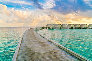 Beautiful water villas in tropical Maldives island at the sunset