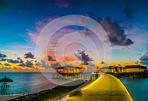 Beautiful water villas in tropical Maldives island at the sunset