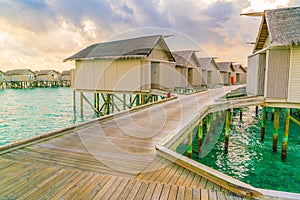 Beautiful water villas in tropical Maldives island at the sunset