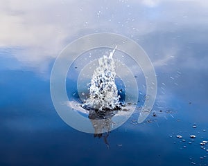 Beautiful water waves and ripples from a drop falling into a water surface of a lake