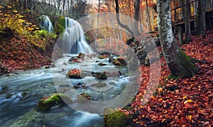 Beautiful waterfall in autumn forest in crimean mountains at sun