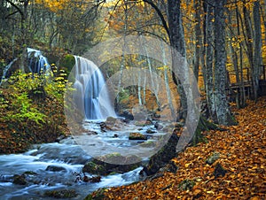 Beautiful waterfall in autumn forest in crimean mountains at sun