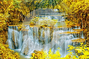 Beautiful waterfall in autumn forest with ray light.