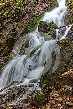 Beautiful waterfall flowing between moss-covered rocks